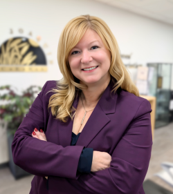 CEO Renee Ostrander in a purple blazer crossing her arms and smiling warmly at the camera.