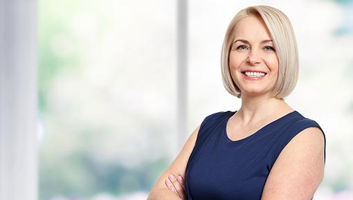 Woman standing with arms crossed in business attire. 